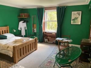 a bedroom with a bed and a green wall at Mansefield Rooms in Lockerbie