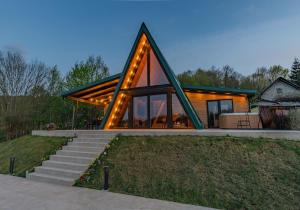 a house with a triangular roof with lights on it at Kuća za odmor Kiara - bazen, jacuzzi i sauna in Karlovac
