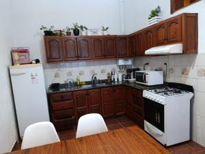 a kitchen with wooden cabinets and a white refrigerator at Comfortable house in La Falda in La Falda