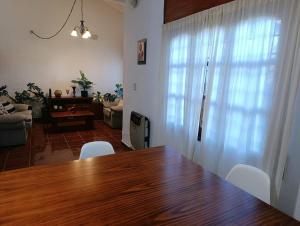 a dining room with a wooden table and white chairs at Comfortable house in La Falda in La Falda