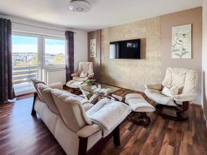 a living room with a couch and chairs and a tv at Blissberg Winterberg in Winterberg