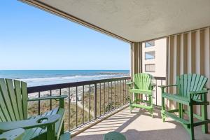 a balcony with two chairs and the beach at Sandy Bits Oceanfront Premium Condo with Pool in Myrtle Beach