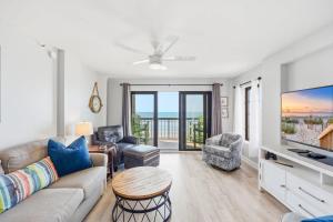 a living room with a couch and a tv at Sandy Bits Oceanfront Premium Condo with Pool in Myrtle Beach