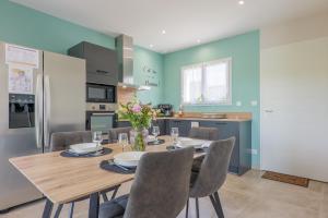 a kitchen and dining room with a wooden table and chairs at Villa Lisa in Balazuc