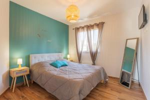 a bedroom with a bed with a blue wall at Villa Lisa in Balazuc