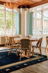 a dining room with a wooden table and chairs at La Maison du Bassin in Cap-Ferret