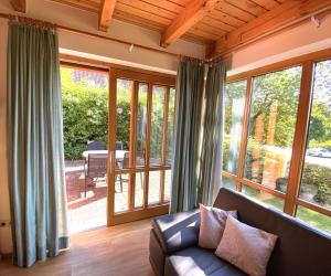 a living room with a couch and large windows at Haus 16 im Natur Ferienpark, Natur, Abenteuer und Entspannung für unvergessliche Urlaubstage in Nieheim