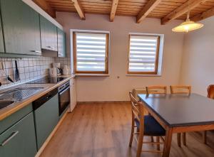 a kitchen with a table and chairs in a room at Haus 16 im Natur Ferienpark, Natur, Abenteuer und Entspannung für unvergessliche Urlaubstage in Nieheim