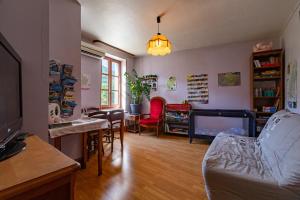 a living room with a couch and a dining room at La Charrette in Dunières-sur-Eyrieux