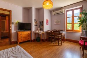 a living room with a tv and a table and chairs at La Charrette in Dunières-sur-Eyrieux
