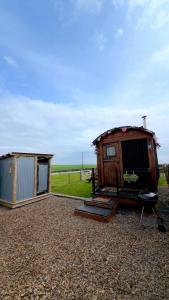 a couple of huts sitting on top of a gravel field at The Black Sheep Shepherd's Hut in Prestrie