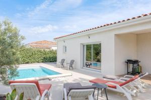 a patio with chairs and a swimming pool at Villa Flora in Balazuc