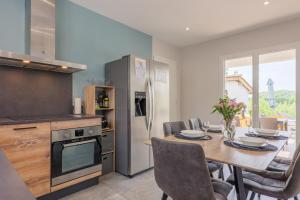 a kitchen with a wooden table and a dining room at Villa Flora in Balazuc