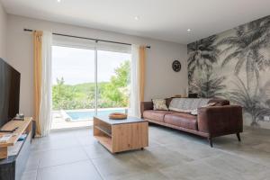 a living room with a couch and a large window at Villa Flora in Balazuc