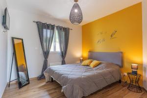 a bedroom with a bed and a yellow wall at Villa Flora in Balazuc +14 photos