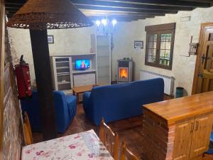 a living room with a blue couch and a tv at Los Avellanos Casa 1 in Celis