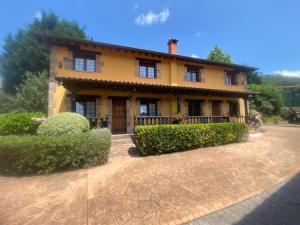 a yellow house with bushes in front of it at Los Avellanos Casa 1 in Celis