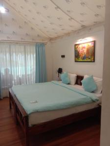 a bedroom with a large bed with a painting on the ceiling at Krishna's den- a cottage retreat a Gaudham Periyar Farmstay in Jambhulpāda