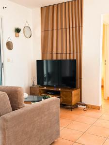 a living room with a large flat screen tv at L'ile au Paon in Les Abymes