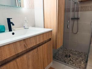 a bathroom with a sink and a shower at L'ile au Paon in Les Abymes +4 photos