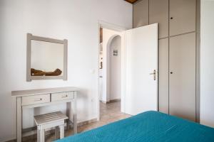 a bedroom with a bed and a mirror at Serenity Apartments, Next to the Beach in Agios Georgios