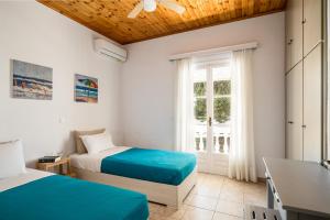 a bedroom with two beds and a window at Serenity Apartments, Next to the Beach in Agios Georgios