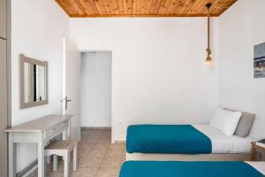 a bedroom with a bed and a desk with a mirror at Serenity Apartments, Next to the Beach in Agios Georgios