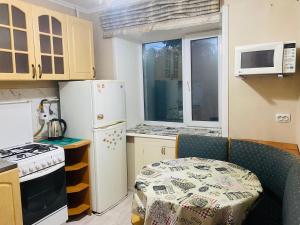 a small kitchen with a table and a microwave at Comfort Home Gogolya in Karagandy