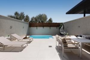 a patio with lounge chairs and a swimming pool at Coral suites Boutique in Eilat
