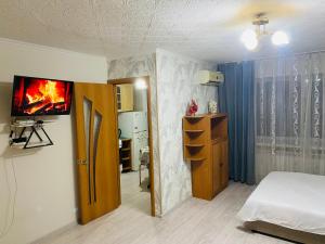 a bedroom with a bed and a tv on a wall at Comfort Home Gogolya in Karagandy