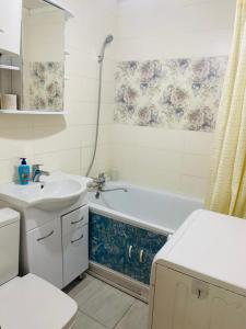 a bathroom with a sink and a tub and a toilet at Comfort Home Gogolya in Karagandy