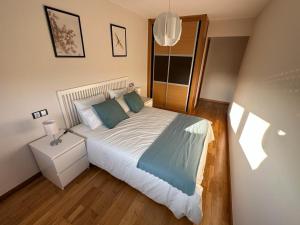 a bedroom with a large bed and a night stand at Playa América 2C by YBH in Nigrán