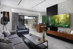 a living room with a couch and a tv at Coral suites Boutique in Eilat