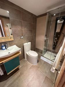 a bathroom with a toilet and a sink and a shower at Playa América 2C by YBH in Nigrán