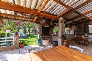 an outdoor kitchen with a wooden table and chairs at La Charrette in Dunières-sur-Eyrieux