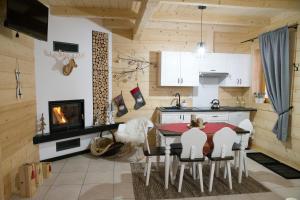 MizernaにあるDomki letniskowe całoroczneのキッチン(テーブル、椅子、暖炉付)