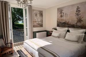 a bedroom with a large bed with a large window at La Maison 1680 in Couches
