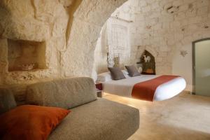 a bedroom with a king sized bed and a couch at Puntebianche Resort in Ceglie Messapica +50 photos