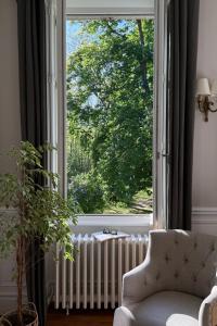 a living room with a large window and a radiator at La Maison 1680 in Couches