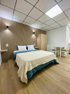 a bedroom with a large bed and a table at BEACH Arguineguin FIRST LINE CHG FAMILY HOTEL in Arguineguín