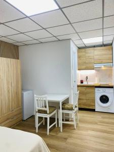 a room with a table and two chairs and a kitchen at BEACH Arguineguin FIRST LINE CHG FAMILY HOTEL in Arguineguín +27 photos