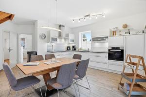 a kitchen and dining room with a wooden table and chairs at Nordseeperle in Greetsiel