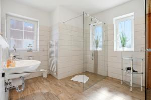 a white bathroom with a sink and a shower at Nordseeperle in Greetsiel +27 photos