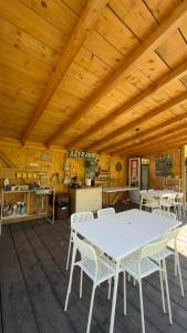 a dining room with a white table and chairs at Cabane A-Frame Svinița in Sviniţa