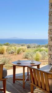 a table and chairs on a patio with a view of the ocean at Egeo Paros in Kampos Paros
