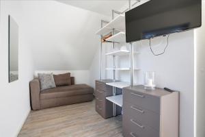 a small living room with a chair and a dresser at Nordseeperle in Greetsiel