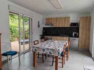a dining room with a table and chairs and a kitchen at Espadrille Océan in Léon