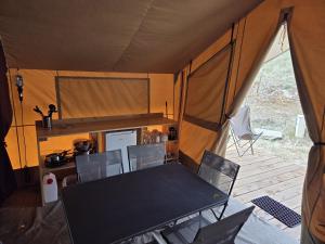 a dining table and chairs in a tent at Camping de Mer - Onlycamp in Cucq