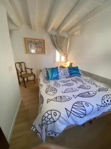 a bedroom with a bed with a fish themed bedspread at casa dei pescatori sottomarina in Chioggia