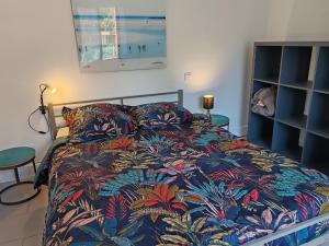 a bedroom with a bed with a colorful blanket at Espadrille Océan in Léon